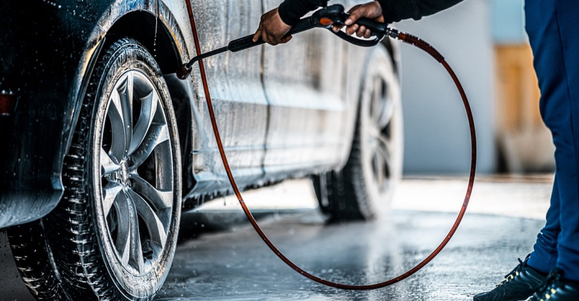 Washing wheel arch with a jet of water in a self service car wash.